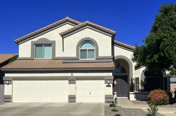 Two-story suburban home featuring a double garage door and driveway